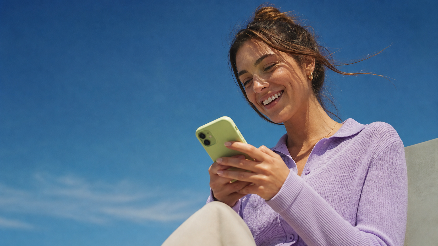 A smiling person using a phone